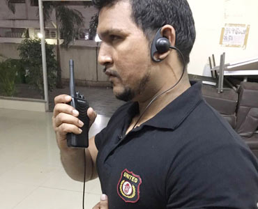 United security officer using a walkie-talkie and earpiece on duty